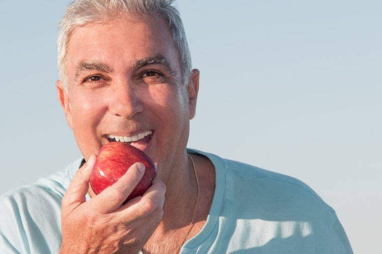 healthy old man eating an apple