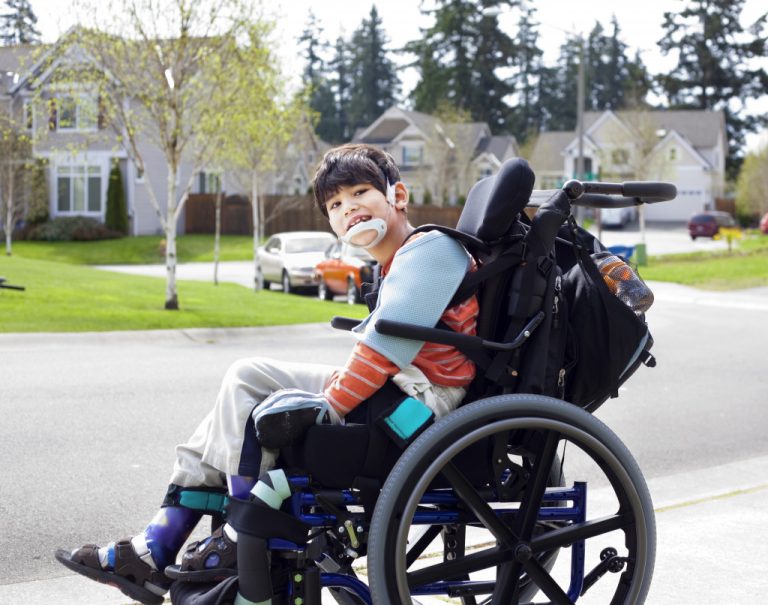 a kid smiling on a wheelchair