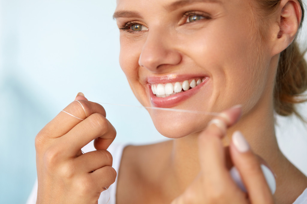 A woman flossing her teeth